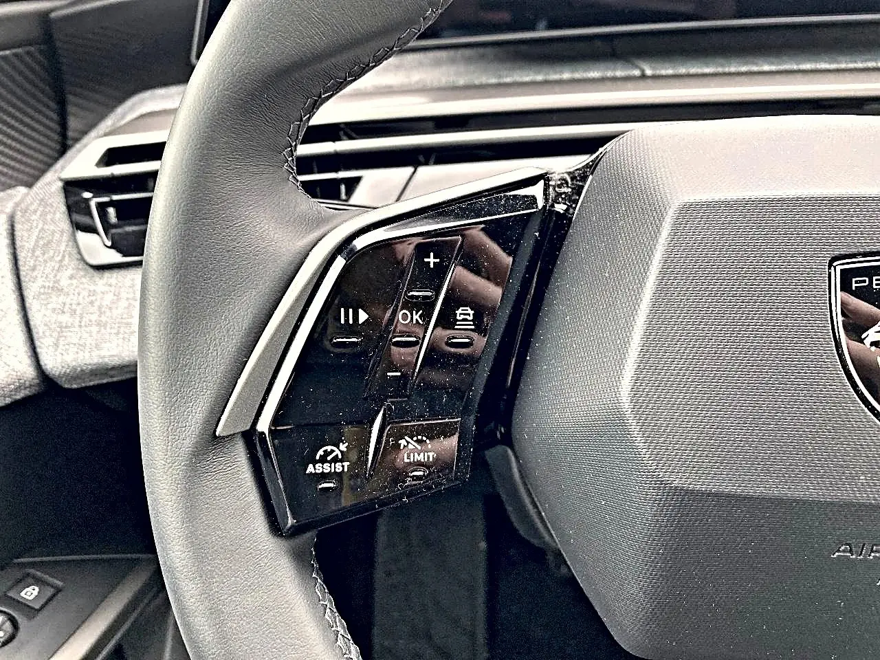 Gros plan sur le volant cuir multifonction côté gauche du Peugeot 3008 2025, avec commandes d'assistance et régulateur.