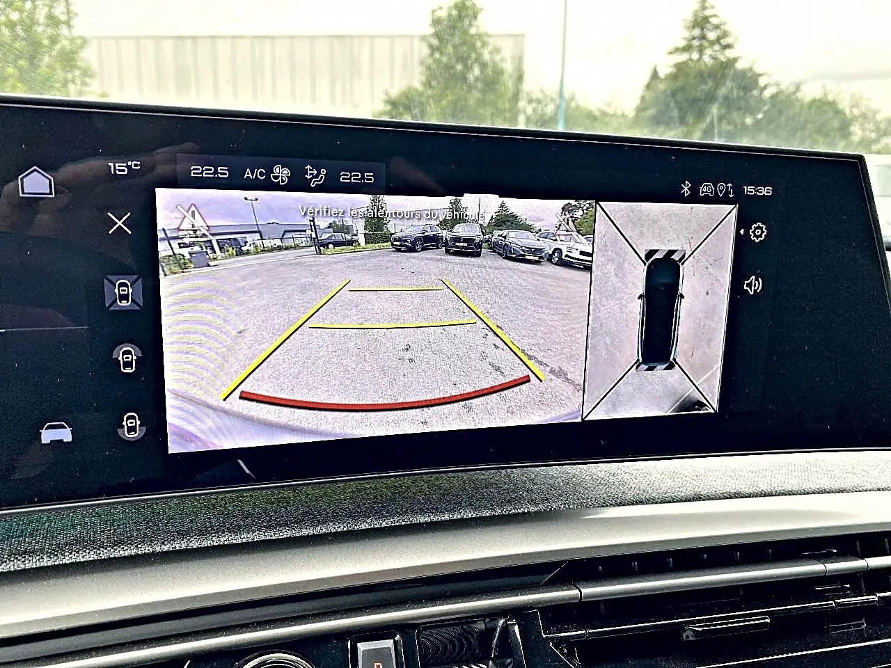 Écran tactile intérieur du Peugeot 3008 bleu 2025 montrant la caméra de recul et vue 360° du véhicule en stationnement.