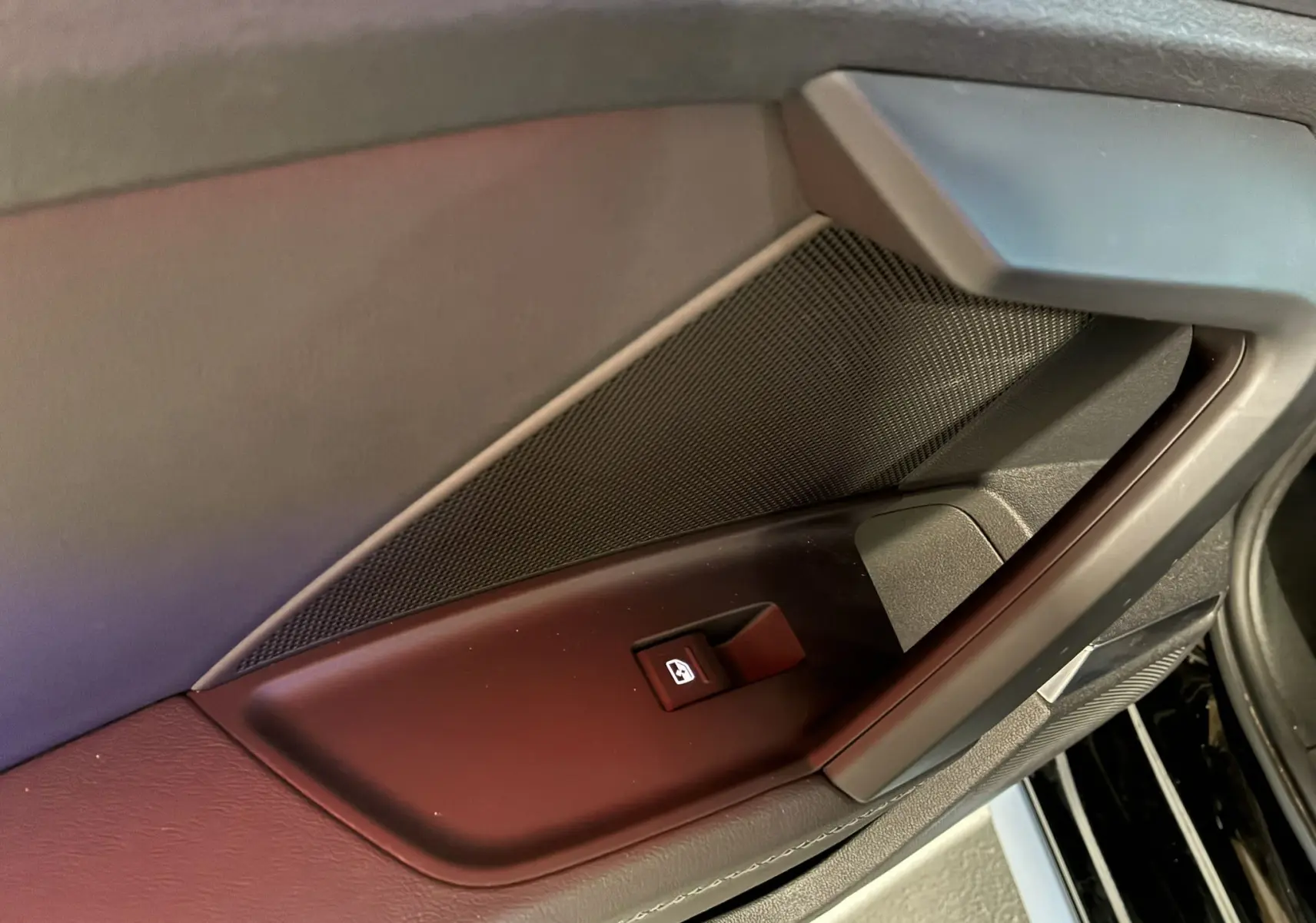 Gros plan sur le bouton de commande de vitre côté gauche de la porte intérieure noire de l'Audi A3 Sportback 2022.