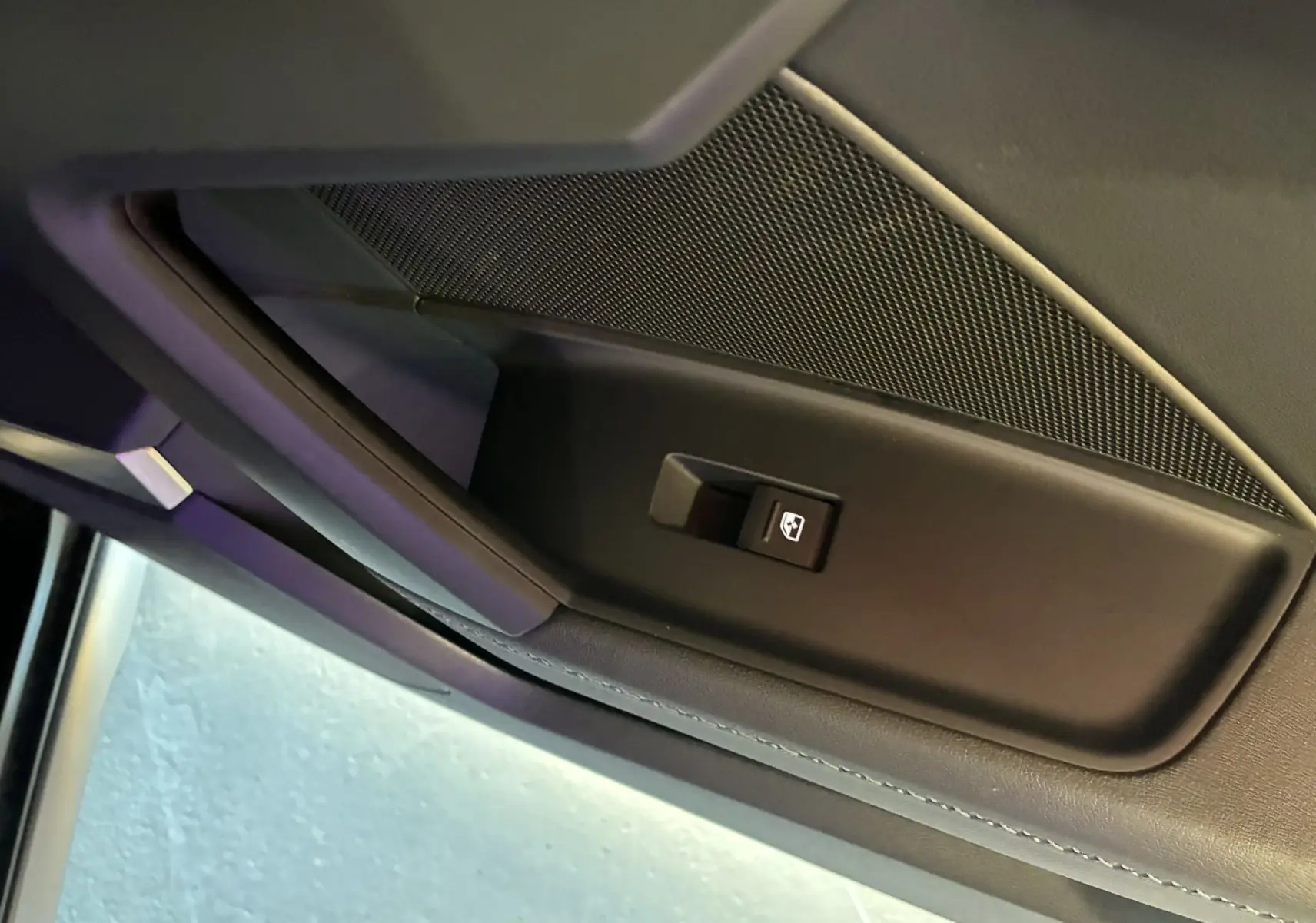 Détail de la commande de lève-vitre sur la porte intérieure côté gauche d'une Audi A3 Sportback noire 2022.
