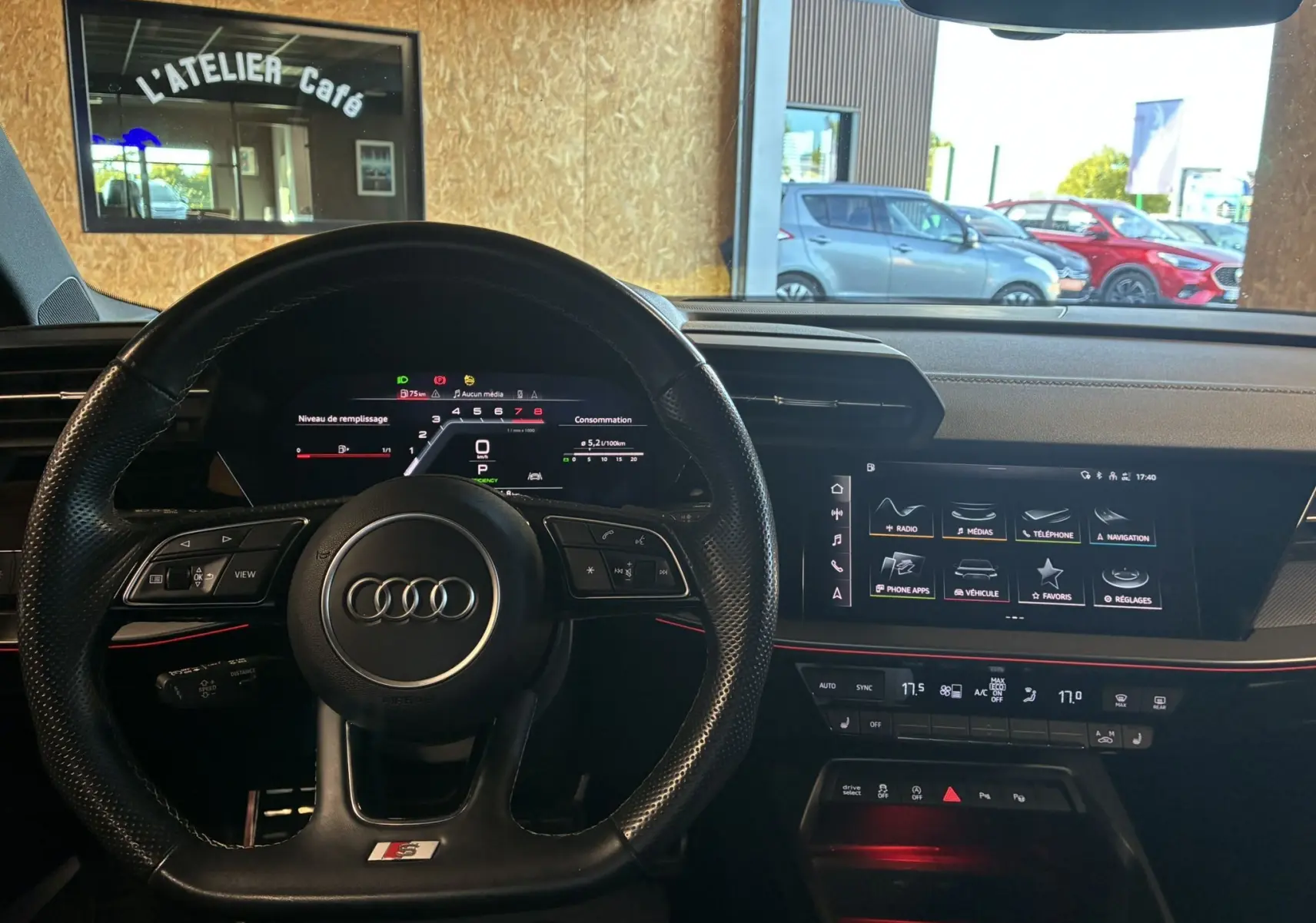 Vue intérieure du tableau de bord et volant noir perforé de l'Audi A3 Sportback 2022 avec écran tactile et affichage numérique.