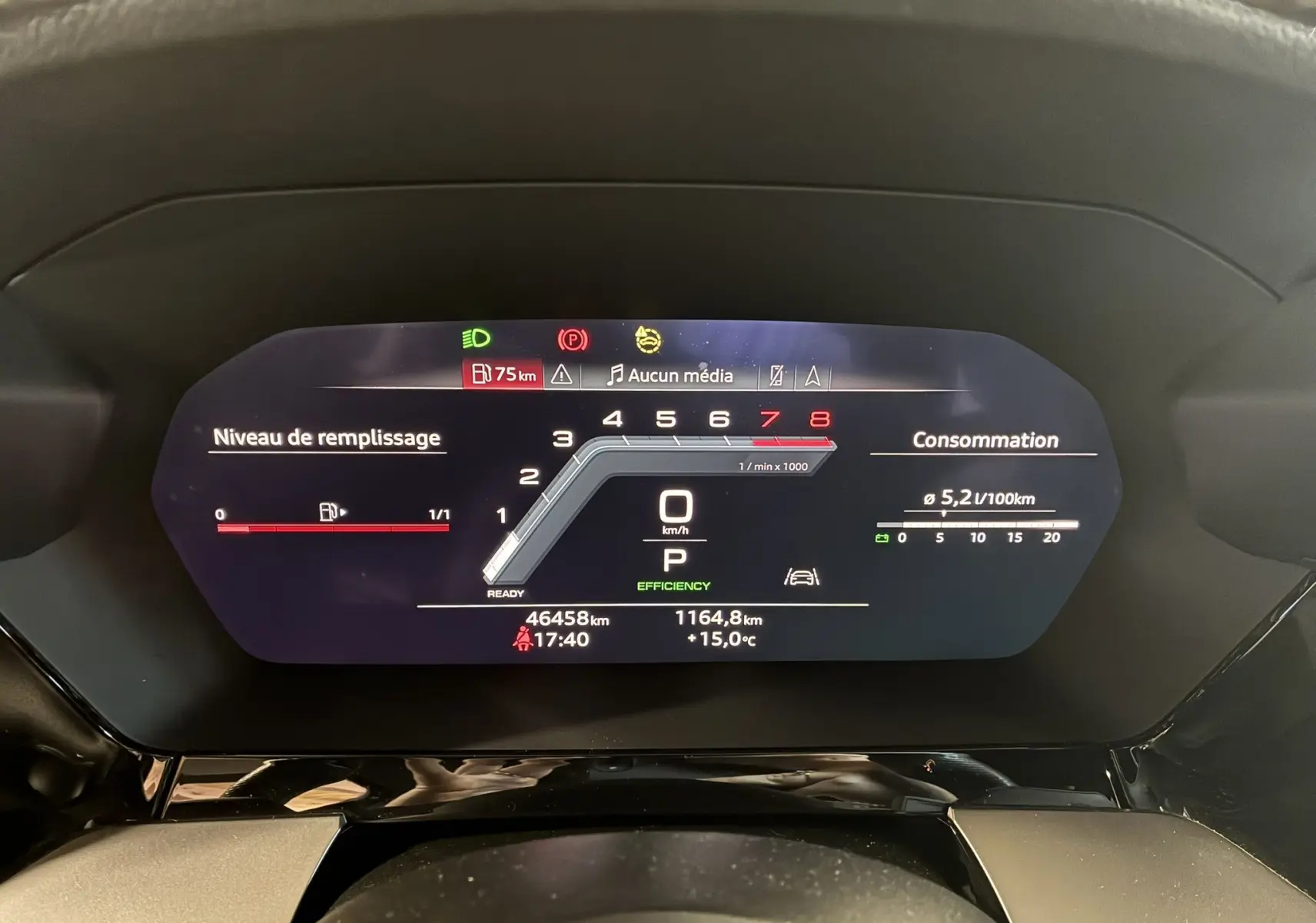 Tableau de bord numérique de l'Audi A3 Sportback noir, affichant vitesse, consommation et niveau de carburant.