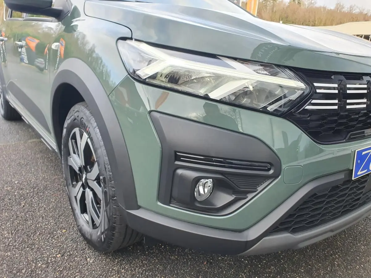 Vue 3/4 avant gauche d'un Dacia Jogger 2024 en vert Licken Kaki avec phares LED et jantes noires bicolores.