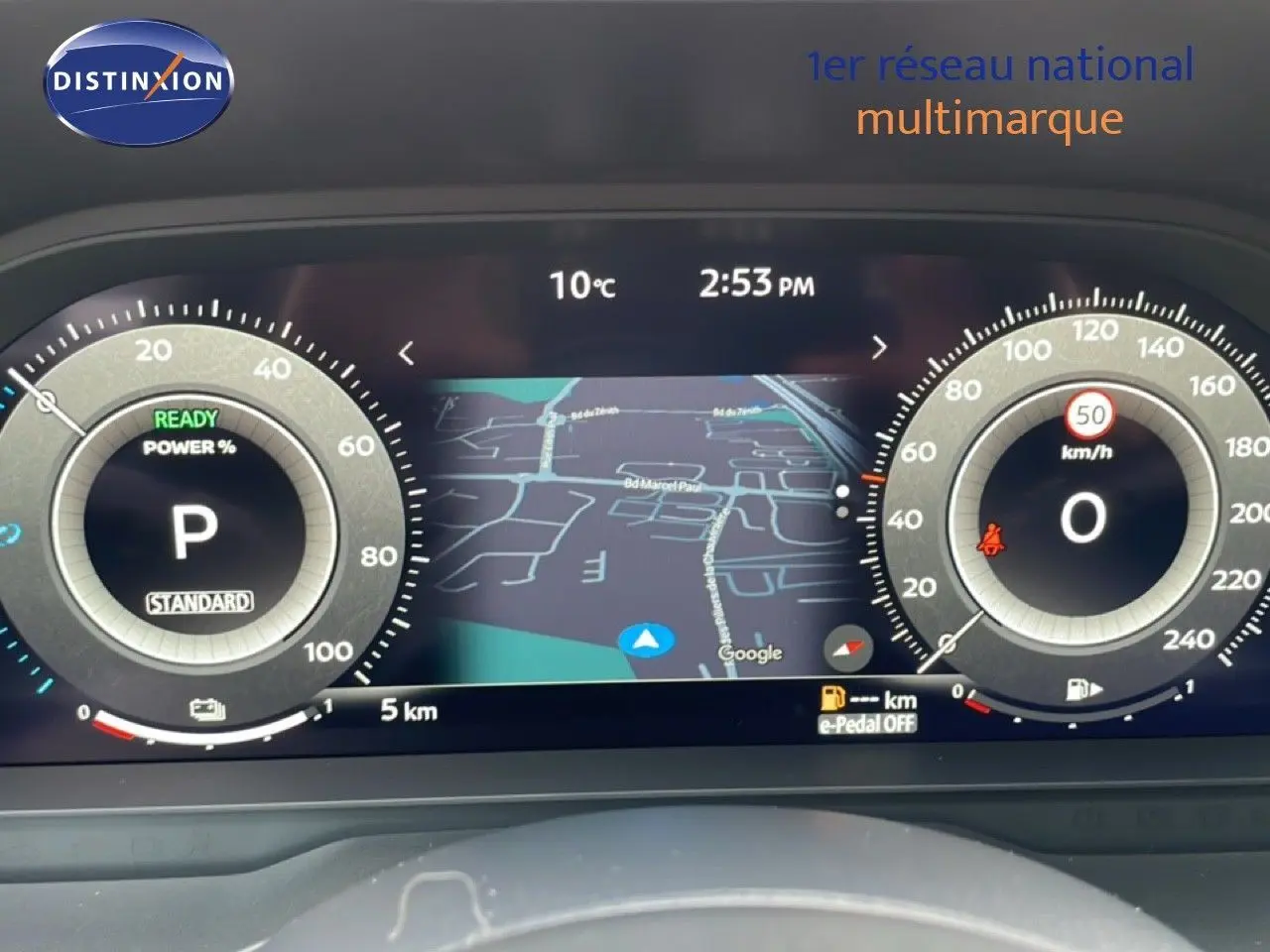 Tableau de bord numérique du Nissan Qashqai 2025 affichant la navigation et les compteurs en mode hybride, vue frontale.