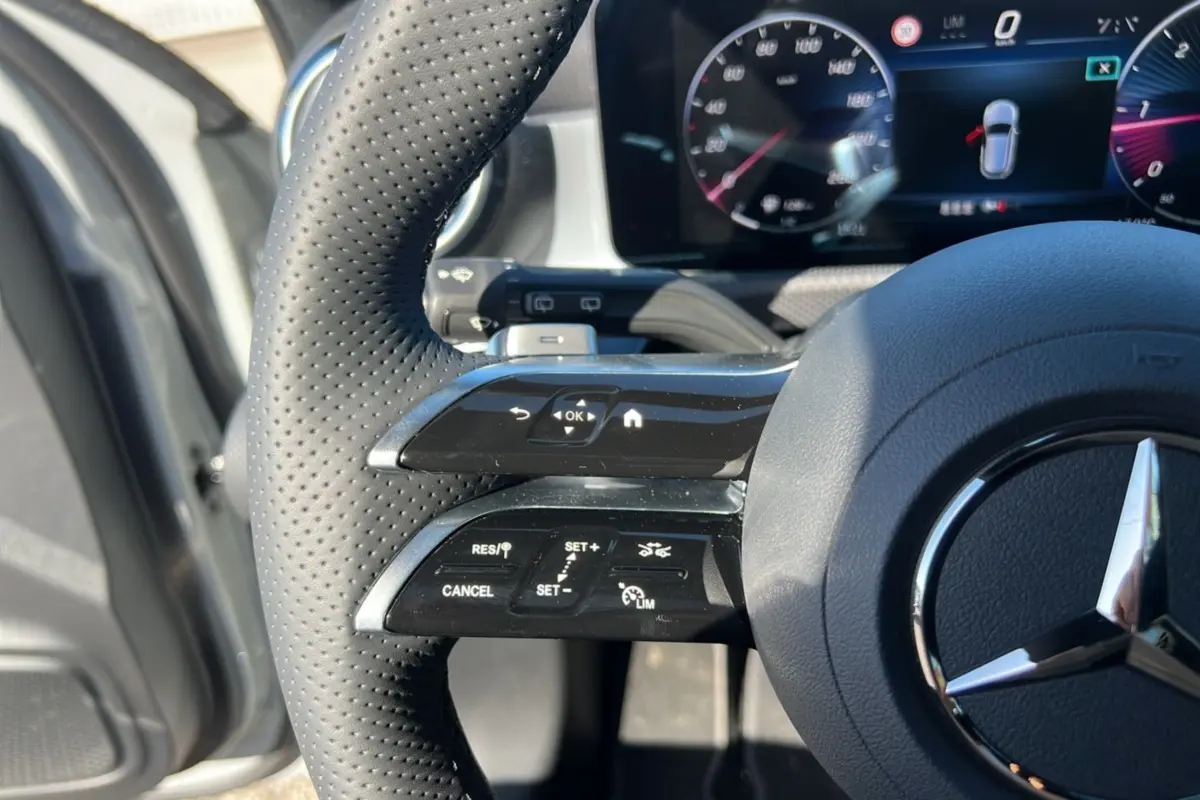 Gros plan sur le volant cuir perforé de la Mercedes Classe A 200D 2026 avec commandes multifonctions et tableau de bord numérique.