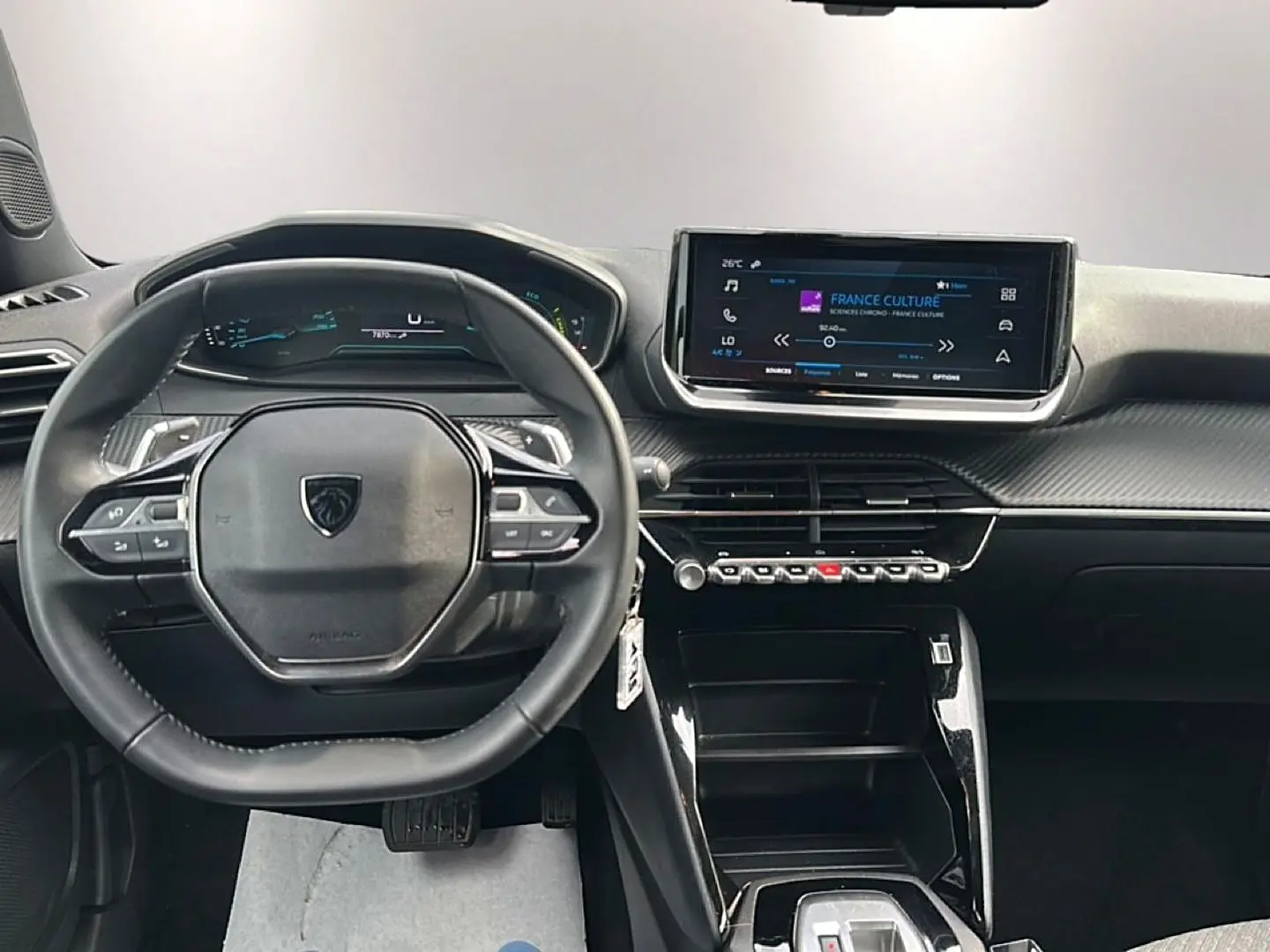 Vue intérieure du tableau de bord et volant de la Peugeot 2008 gris, avec écran tactile central et commandes au volant.