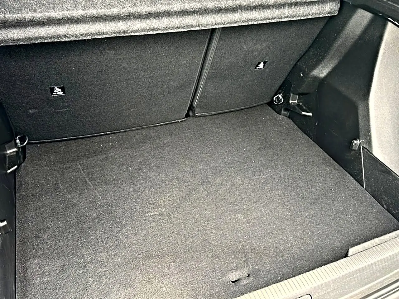 Coffre spacieux gris foncé de Peugeot 2008 1.2 hybrid 145 style, vue intérieure arrière sans chargement.