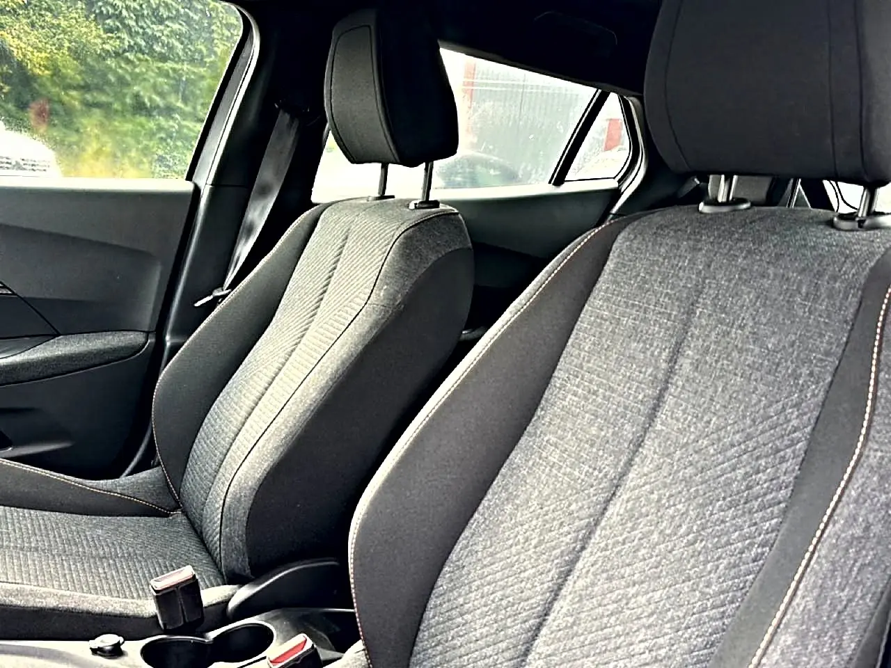 Vue intérieure rapprochée des sièges avant gris du Peugeot 2008 1.2 hybrid 145 style e-dcs6 2025.