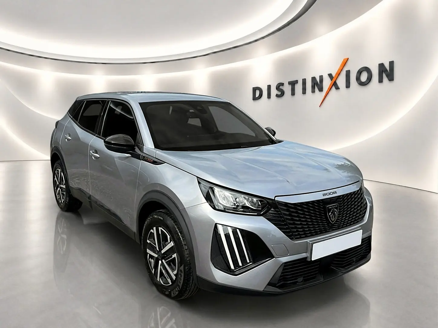 Peugeot 2008 gris en 3/4 avant droit, avec calandre noire et feux LED distinctifs, sur fond blanc lumineux.