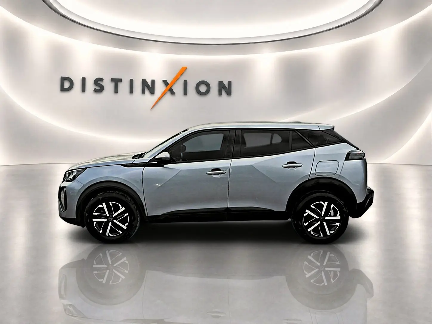 Peugeot 2008 gris en profil droit dans un showroom avec toit noir et jantes noires à motifs lumineux.