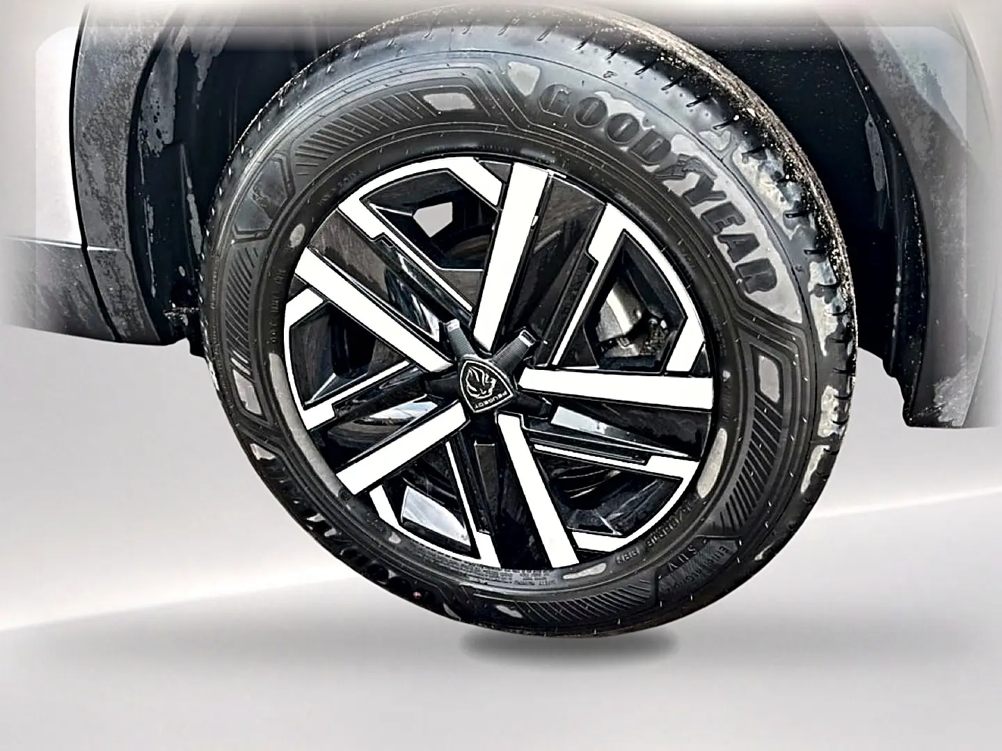 Gros plan sur la roue avant droite du Peugeot 2008 gris, mettant en valeur la jante noire et argentée au design moderne.