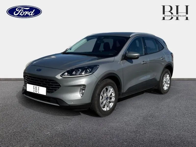 Ford Kuga gris Solar métallisé vu en 3/4 avant droit avec jantes alu et calandre noire distinctive.