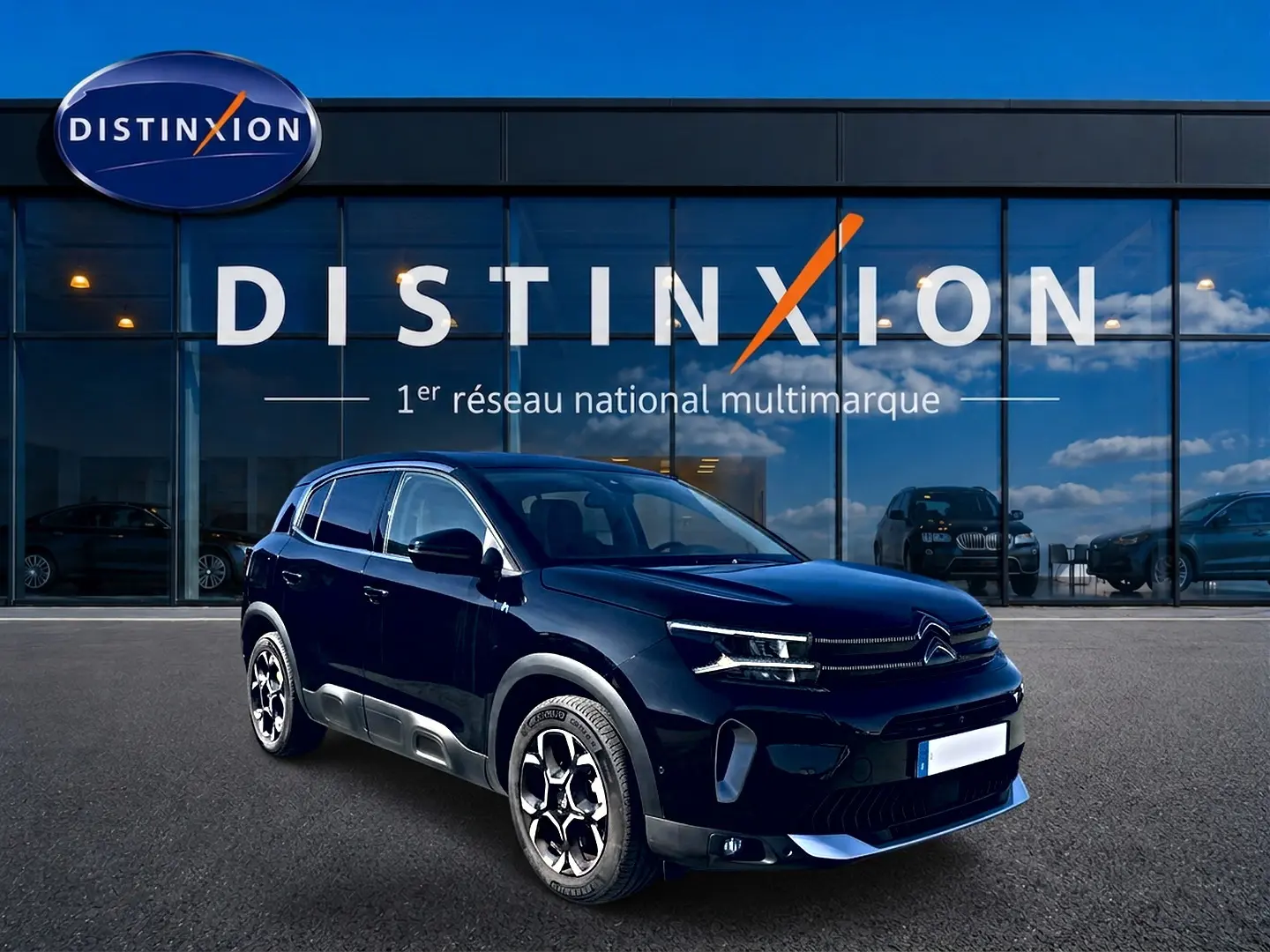 Citroën C5 Aircross hybride noire vue en 3/4 avant droit devant un showroom Distinxion.