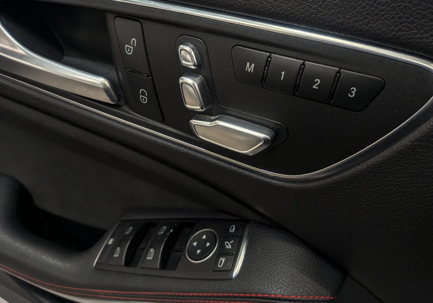 Détail des commandes de réglage électrique des sièges et des vitres côté conducteur d'une Mercedes Classe CLA 200 Fascination.