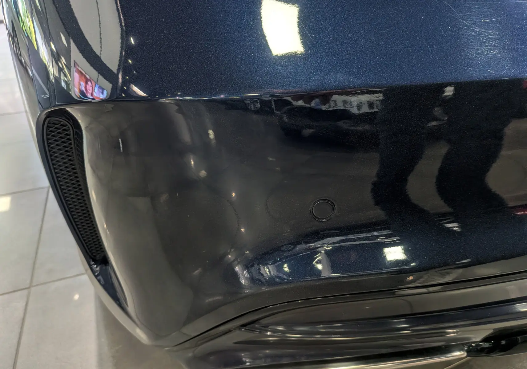 Gros plan sur le pare-chocs arrière bleu Cavansite de la Mercedes CLA 200 Fascination avec capteur de recul intégré.