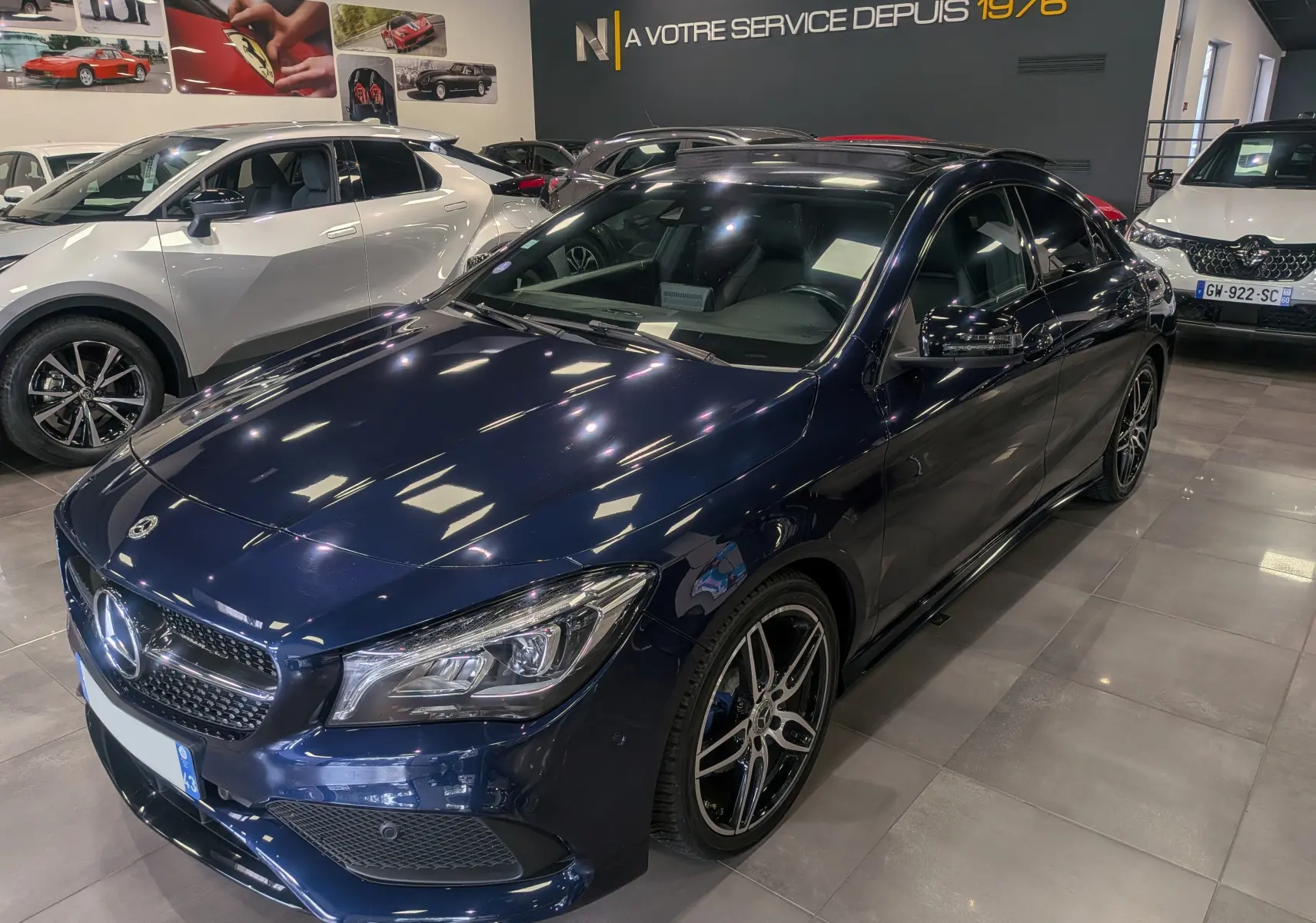Mercedes Classe CLA 200 Fascination bleu Cavansite vue 3/4 avant droit dans un showroom lumineux.