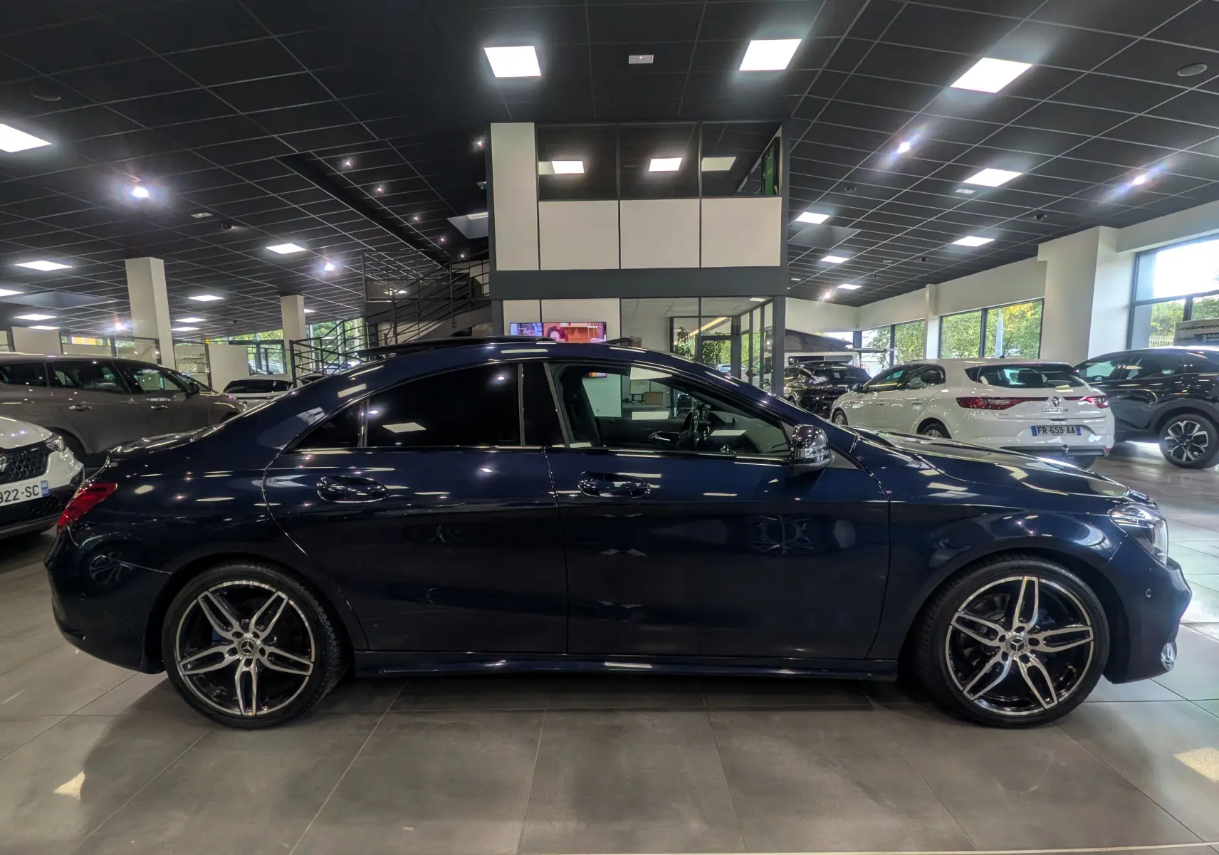 Vue latérale droite d'une Mercedes Classe CLA 200 Fascination 2017 en bleu Cavansite avec jantes AMG 18 pouces bicolores.