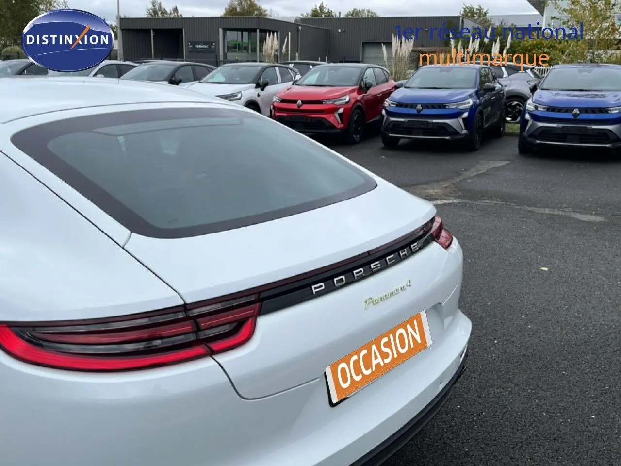 Vue arrière droite d'une Porsche Panamera 4 E-Hybrid blanche avec feux LED et logo Porsche bien visibles.
