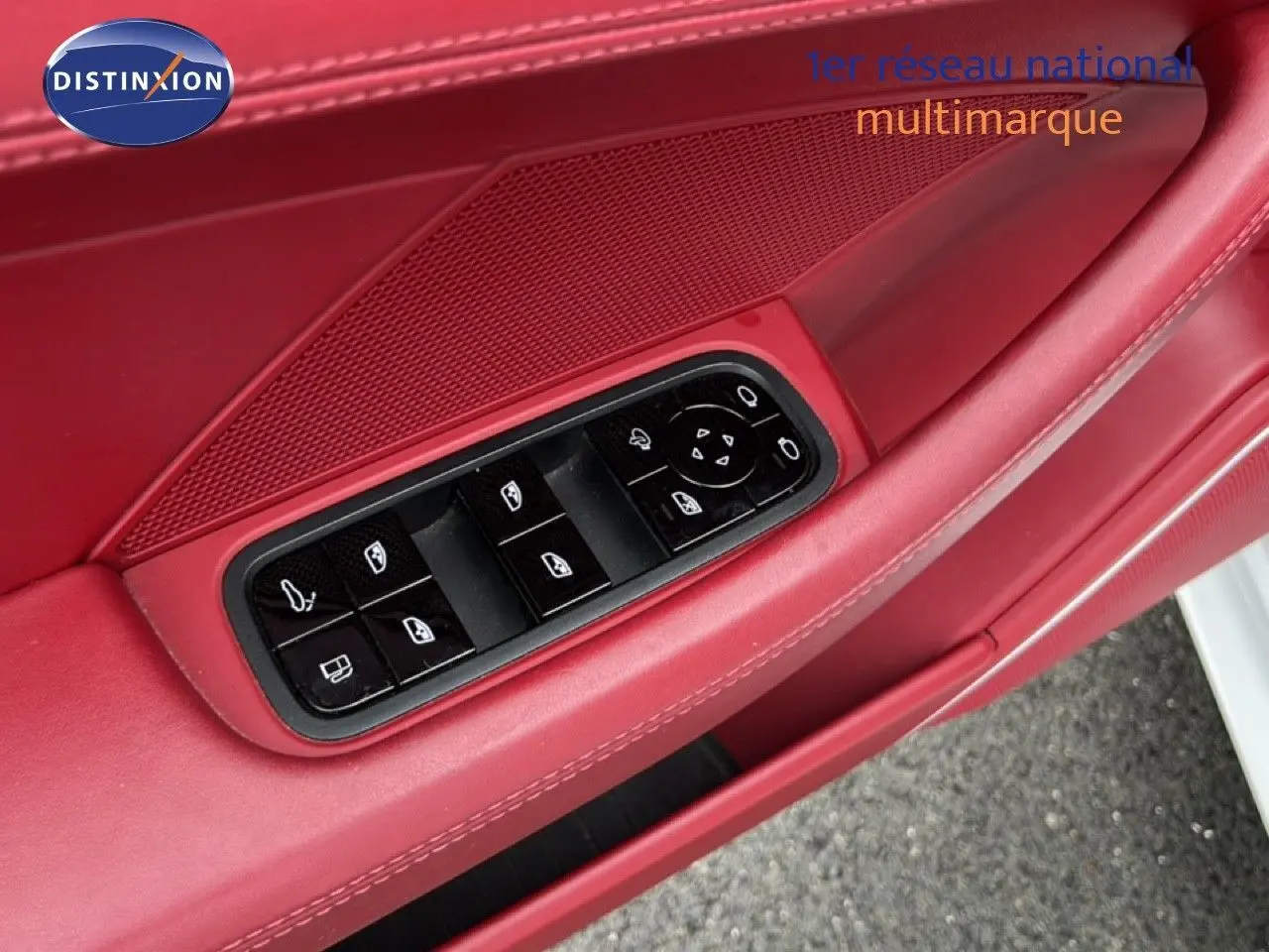 Gros plan sur la garniture rouge de la porte avant gauche d'une Porsche Panamera 4 E-Hybrid avec commandes électriques des vitres.