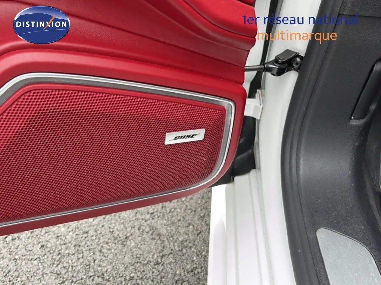 Gros plan sur la porte avant gauche blanche d'une Porsche Panamera 4 E-Hybrid avec enceinte Bose intégrée en rouge.