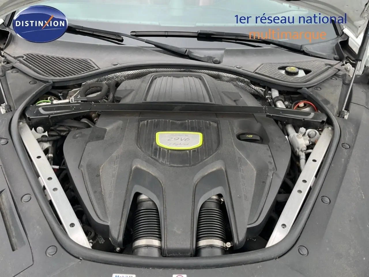 Vue rapprochée du moteur 2.9 V6 hybride de la Porsche Panamera 4 E-Hybrid blanche, capot ouvert.