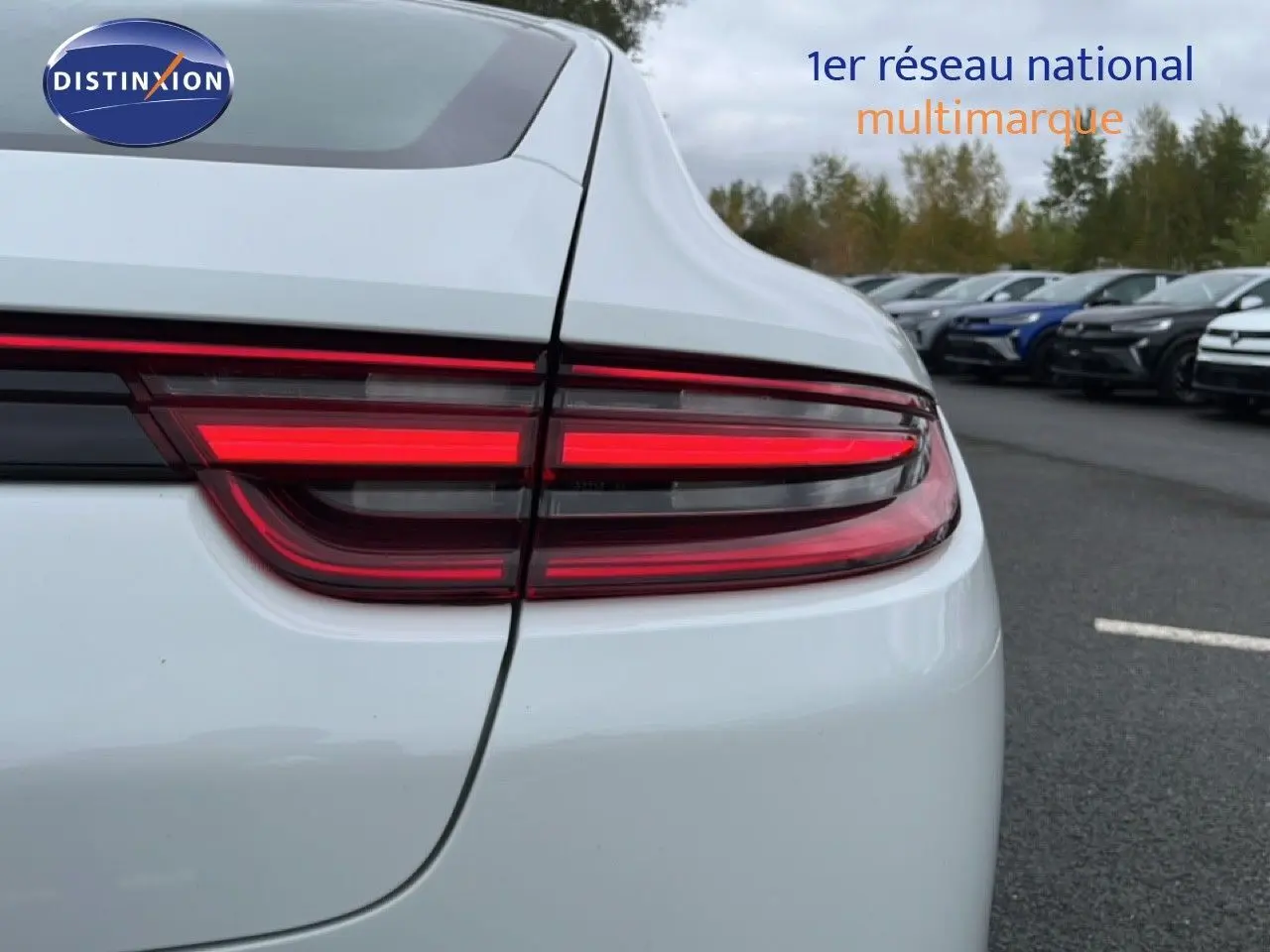 Gros plan sur le feu arrière droit rouge d'une Porsche Panamera 4 E-Hybrid blanche, vue arrière extérieure.