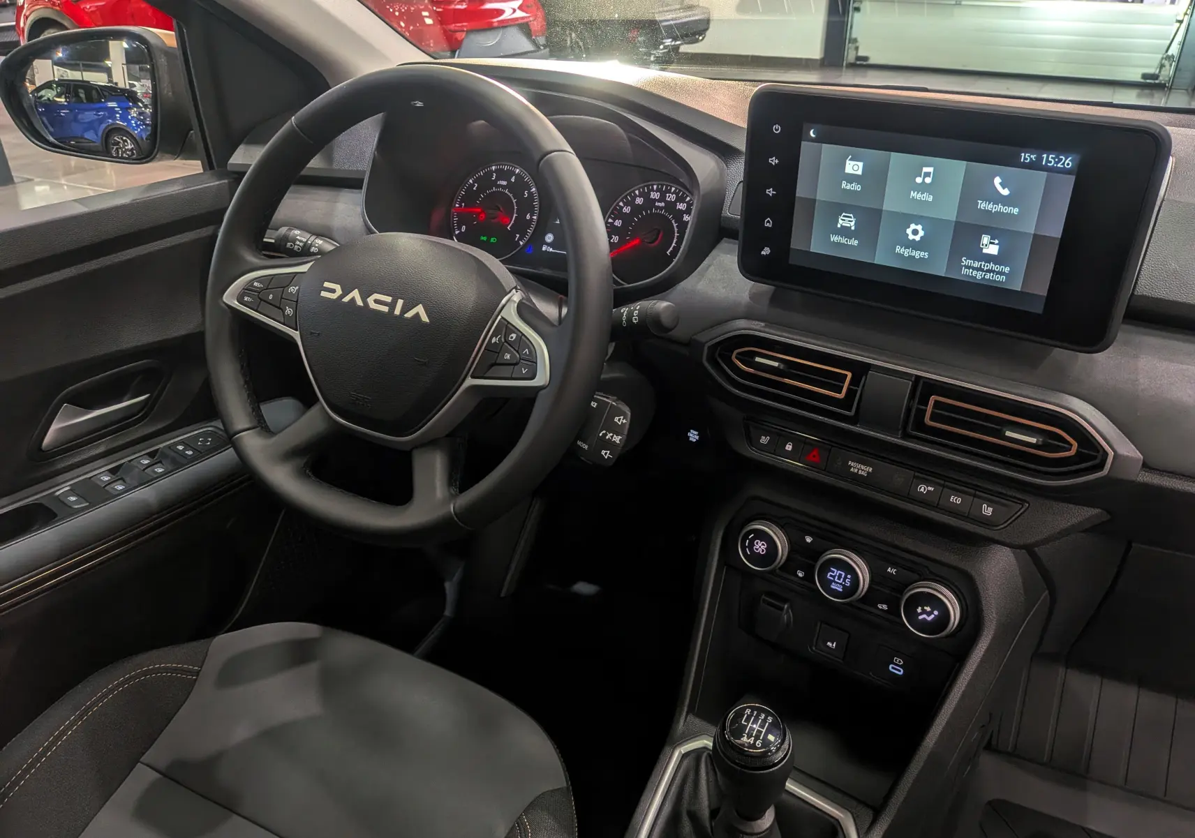 Vue intérieure côté conducteur du tableau de bord et volant DACIA Sandero Stepway 2025 avec écran tactile et boîte manuelle.