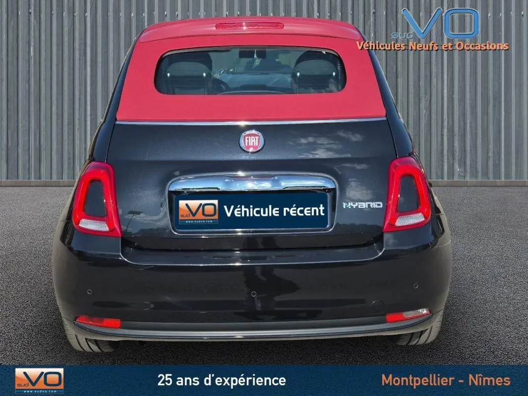 Vue arrière d'une FIAT 500C noire avec toit rouge, version hybride 2024, affichant le logo et l'inscription Hybrid.