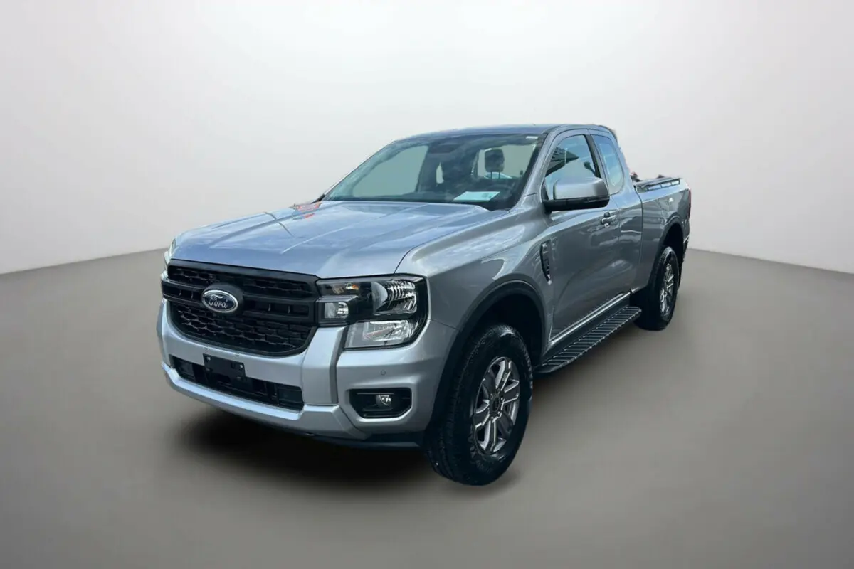Ford Ranger gris iconic en 3/4 avant droit avec marchepieds latéraux et calandre noire distinctive.