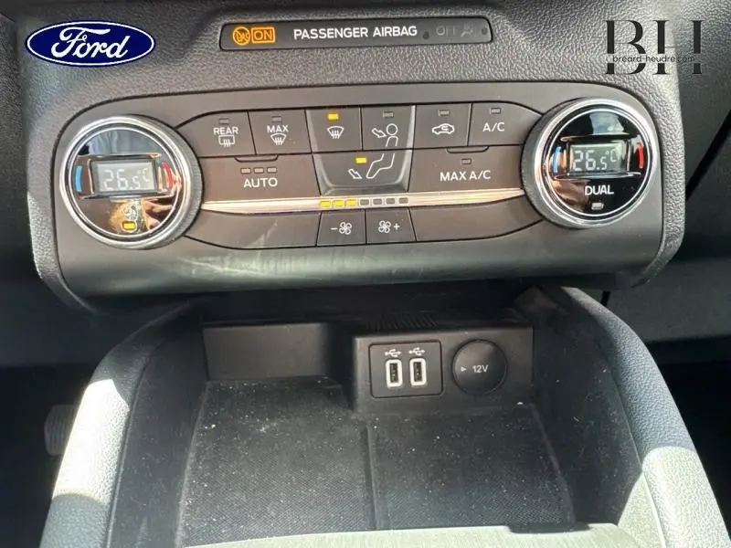 Vue rapprochée de la console centrale du Ford Kuga 2022, montrant la climatisation bi-zone et les ports USB avec prise 12V.