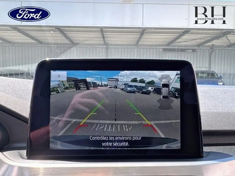Écran tactile intérieur du Ford Kuga 2022 montrant la caméra de recul avec guidage coloré et vue arrière du véhicule.