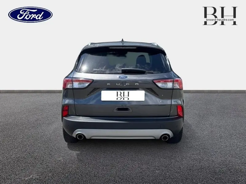 Vue arrière d'un Ford Kuga 1.5 EcoBlue gris Magnetic métallisé avec double sortie d'échappement et vitres arrière surteintées.