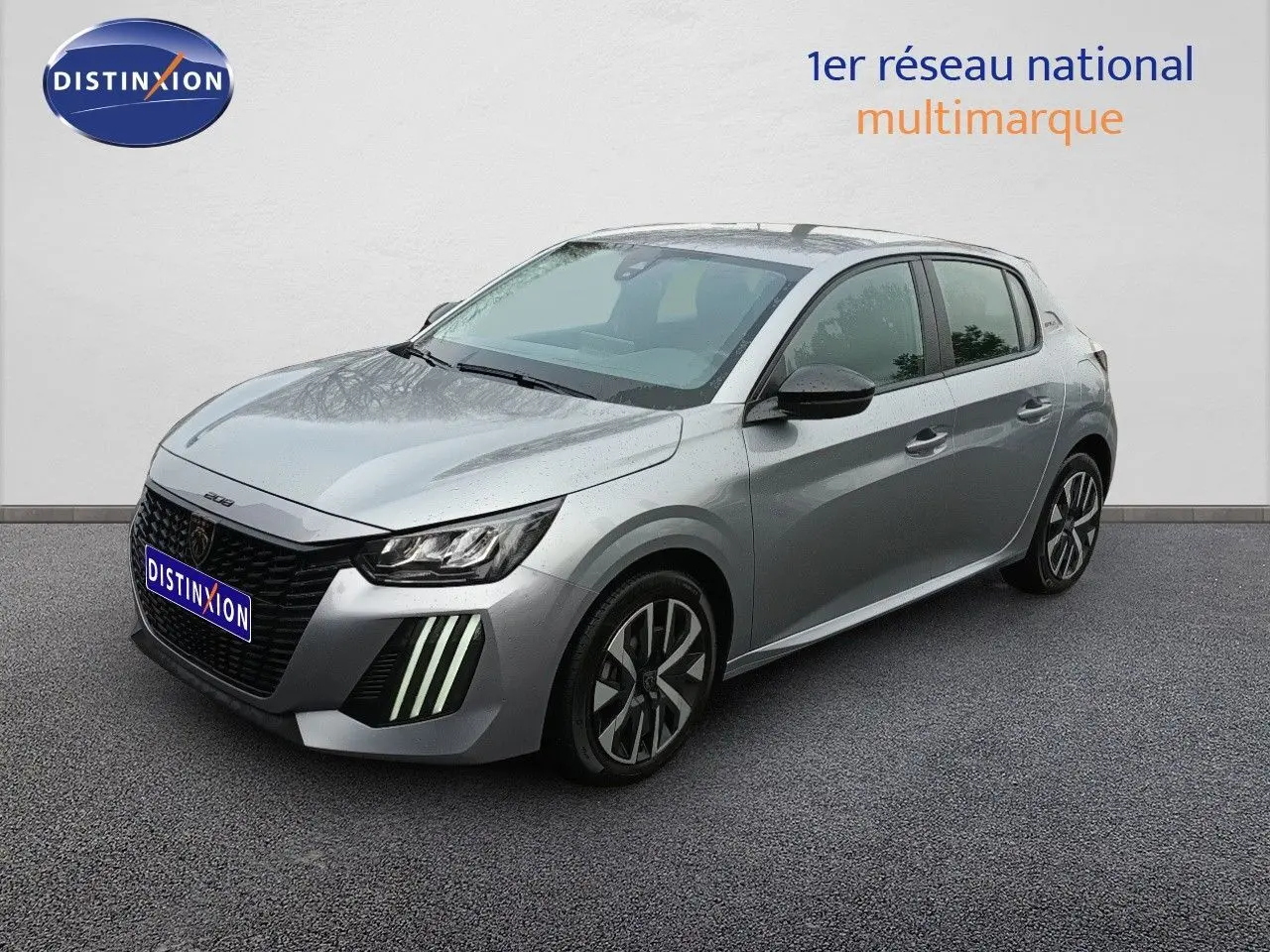 Peugeot 208 gris Artense métal vue 3/4 avant droit, avec feux LED verticaux distinctifs et jantes alliage.