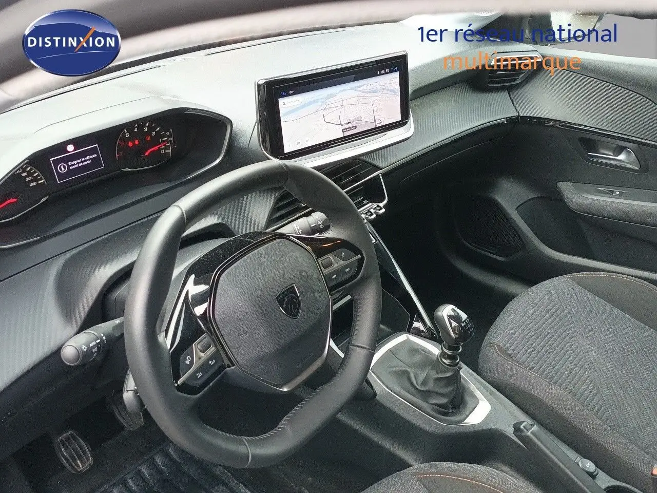 Vue intérieure côté conducteur du Peugeot 208 gris Artense, avec volant cuir multifonction et écran tactile central.