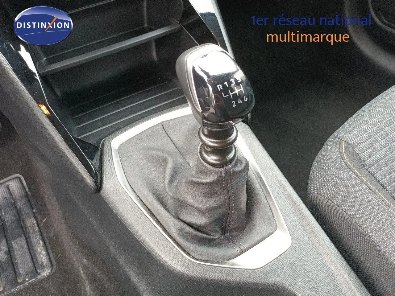 Le levier de vitesses manuel de la Peugeot 208 1.2 100CH S&S STYLE, vue rapprochée de l'intérieur.