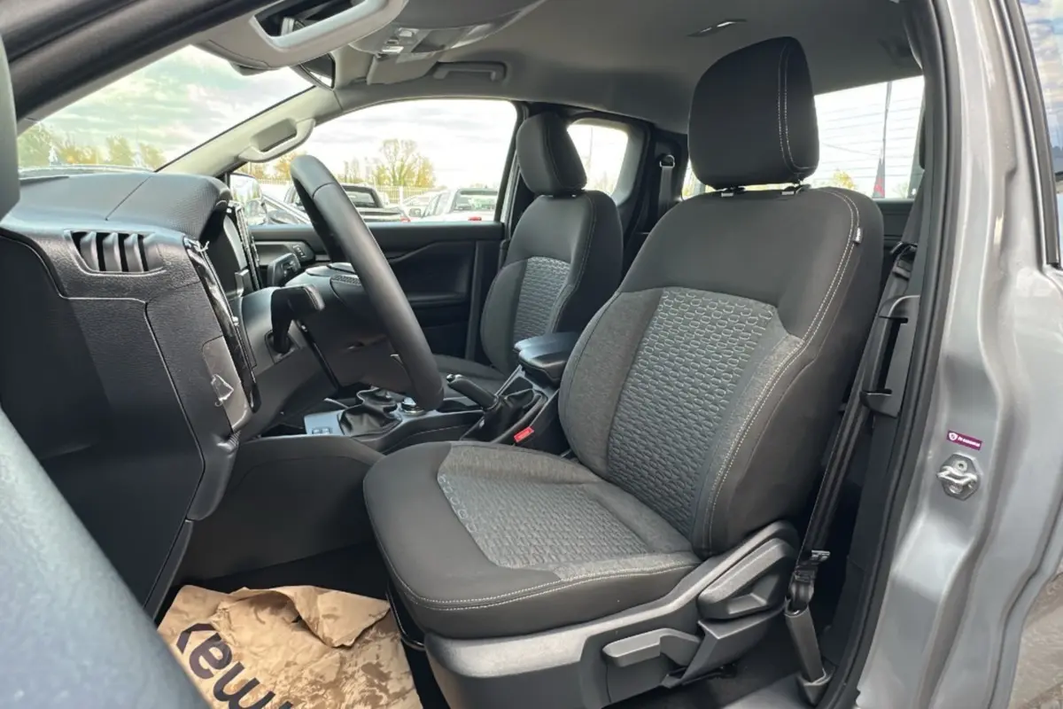 Vue intérieure côté conducteur du Ford Ranger gris iconic 2026, montrant les sièges avant et le volant multifonctions en cuir.