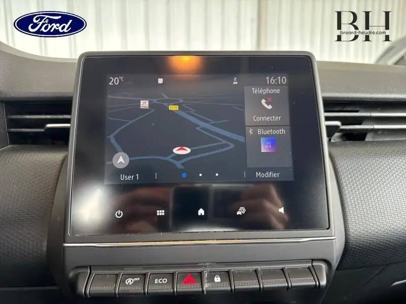 Écran tactile central de navigation et commandes ECO d'une Renault Clio gris platine, vue de face en intérieur.