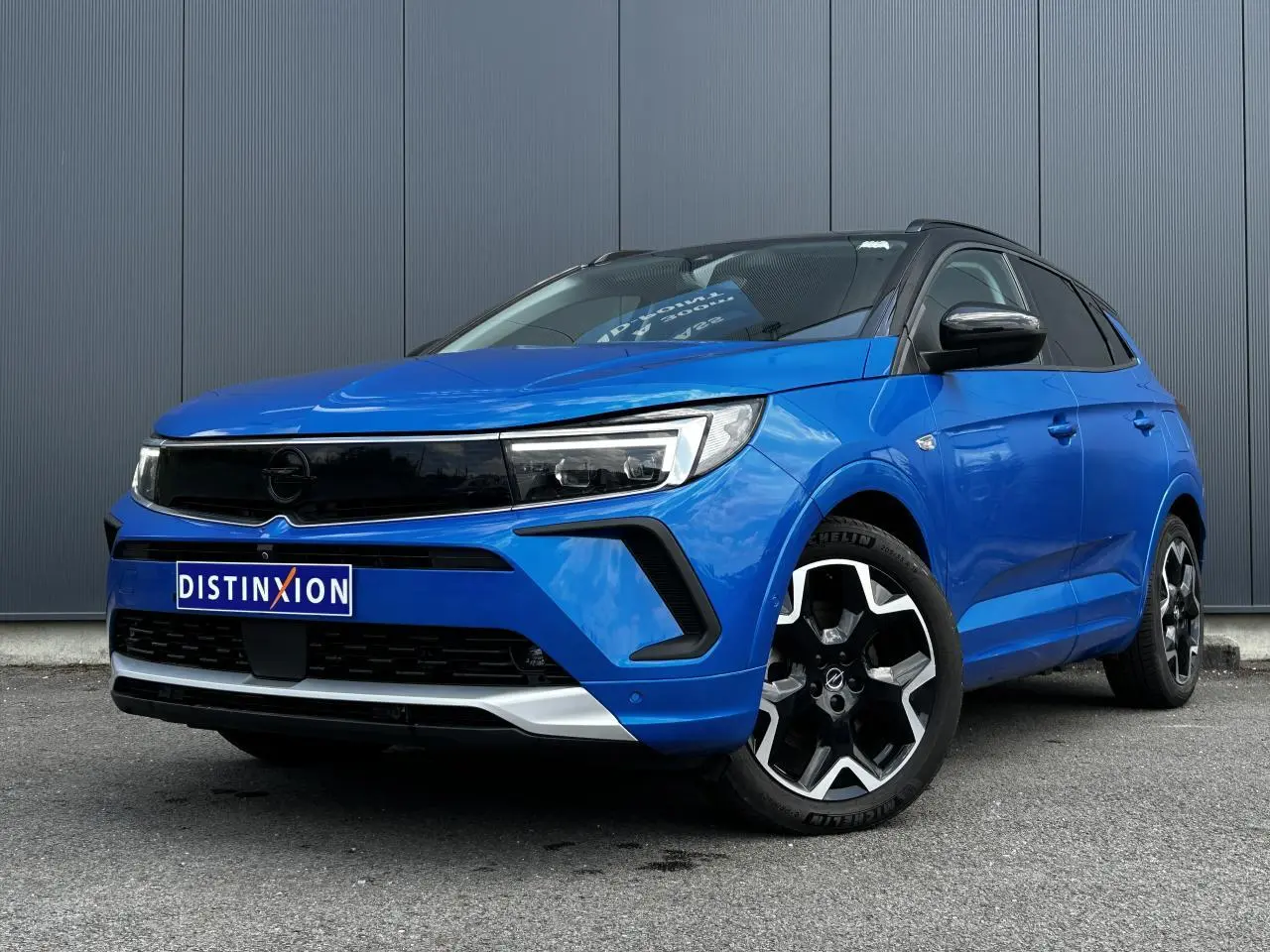 Opel Grandland bleu Vertigo en 3/4 avant droit avec toit noir et jantes alliage noires brillantes
