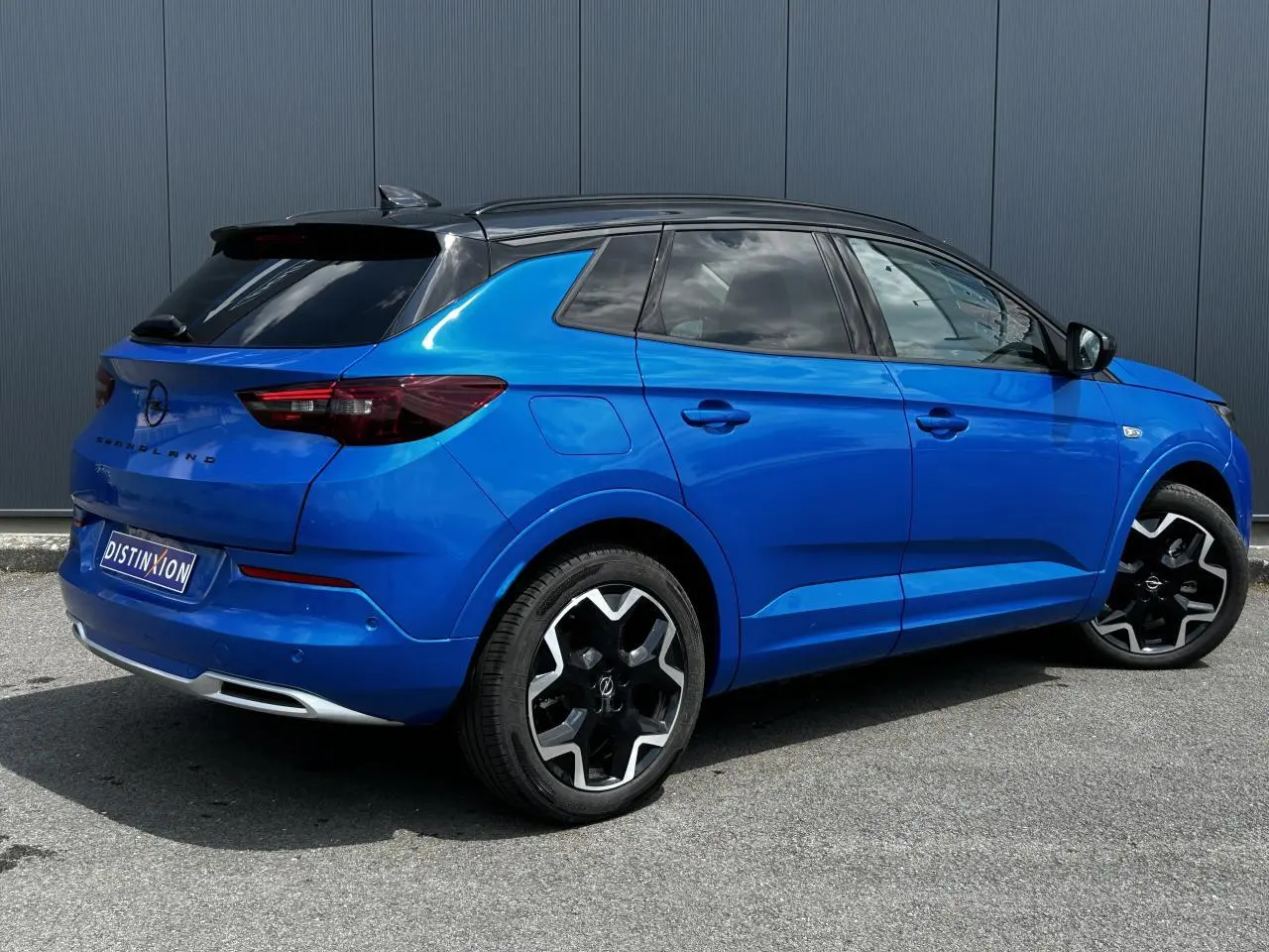 Opel Grandland bleu Vertigo en 3/4 arrière droit avec toit noir et jantes alliage noires brillantes