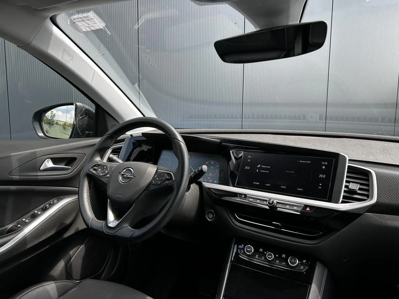 Intérieur de l'Opel Grandland 2022 vu côté conducteur, avec tableau de bord noir et écran tactile large.