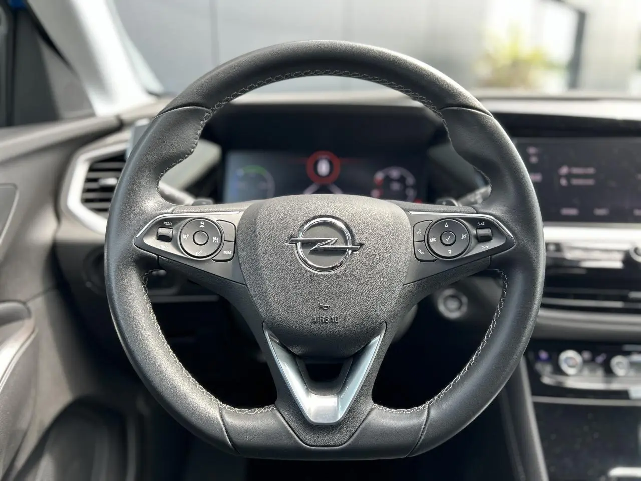 Volant en cuir multifonction de l’Opel Grandland 1.6 Hybrid 225, vue frontale centrée sur le logo Opel