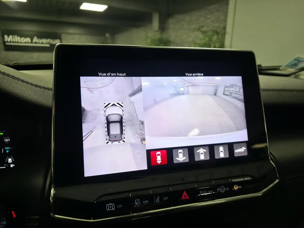 Écran central affichant la caméra 360° et vue arrière du Jeep Compass noir en stationnement intérieur.