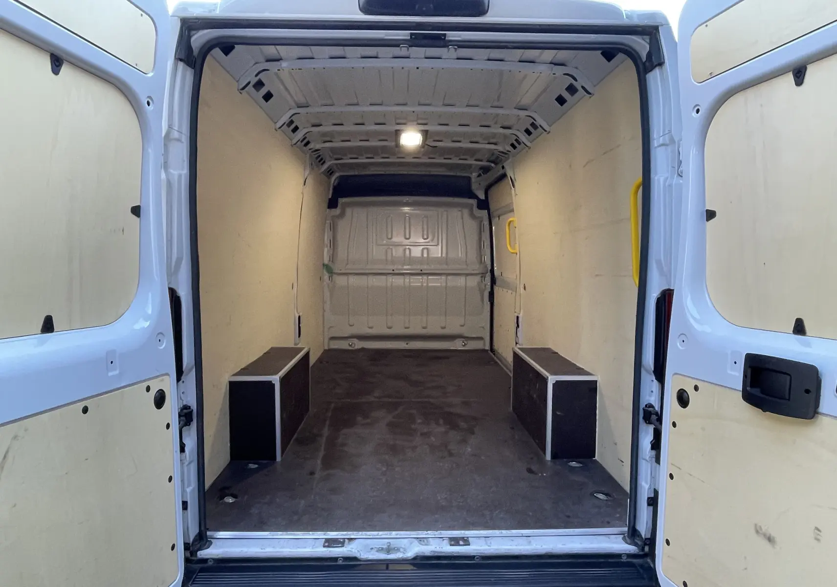 Vue arrière intérieure du Peugeot Boxer Fourgon blanc 2025, montrant l'espace de chargement vide avec portes ouvertes.