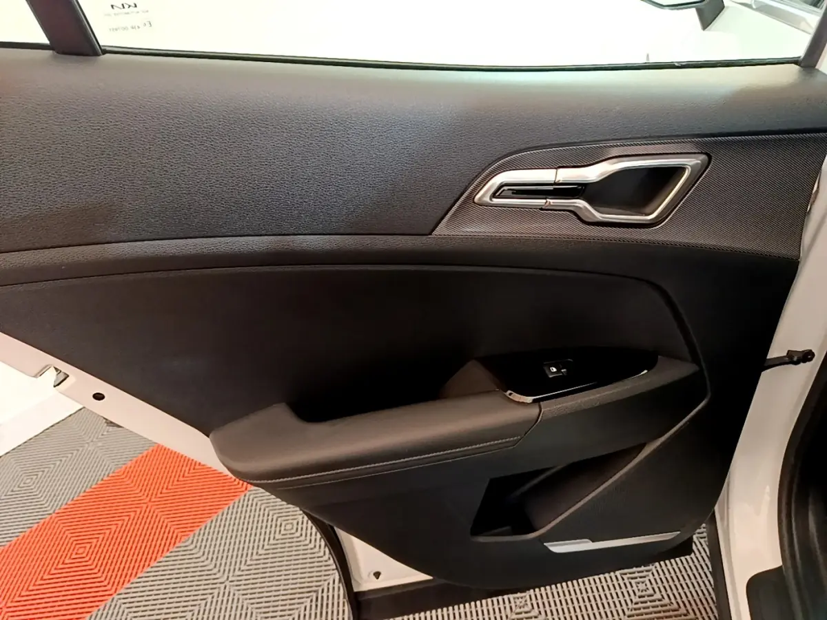 Vue intérieure de la porte avant droite noire avec poignée argentée du Kia Sportage blanc 2022 hybride rechargeable.