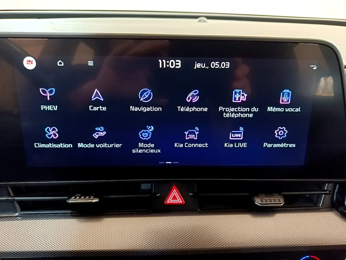 Écran tactile central du tableau de bord du Kia Sportage hybride rechargeable, affichant les options de navigation et connectivité.