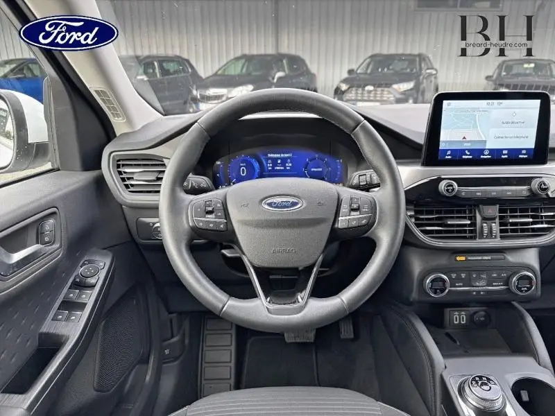 Vue intérieure centrée sur le volant cuir multifonction et tableau de bord numérique du Ford Kuga blanc Glacier 2021.