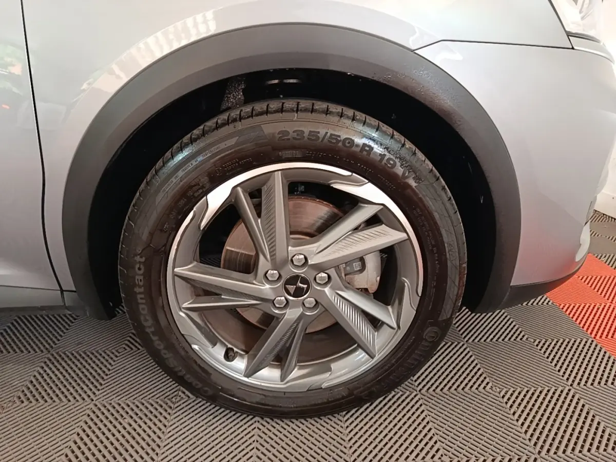 Gros plan sur la roue avant droite gris foncé du DS7 Crossback E-TENSE 225 BUSINESS avec jante alliage distinctive.