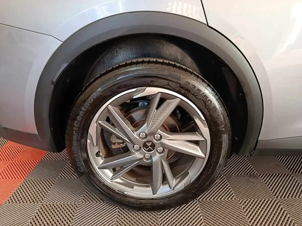 Gros plan sur la roue avant droite gris foncé du DS7 Crossback E-TENSE 225 BUSINESS avec jante alliage distinctive.