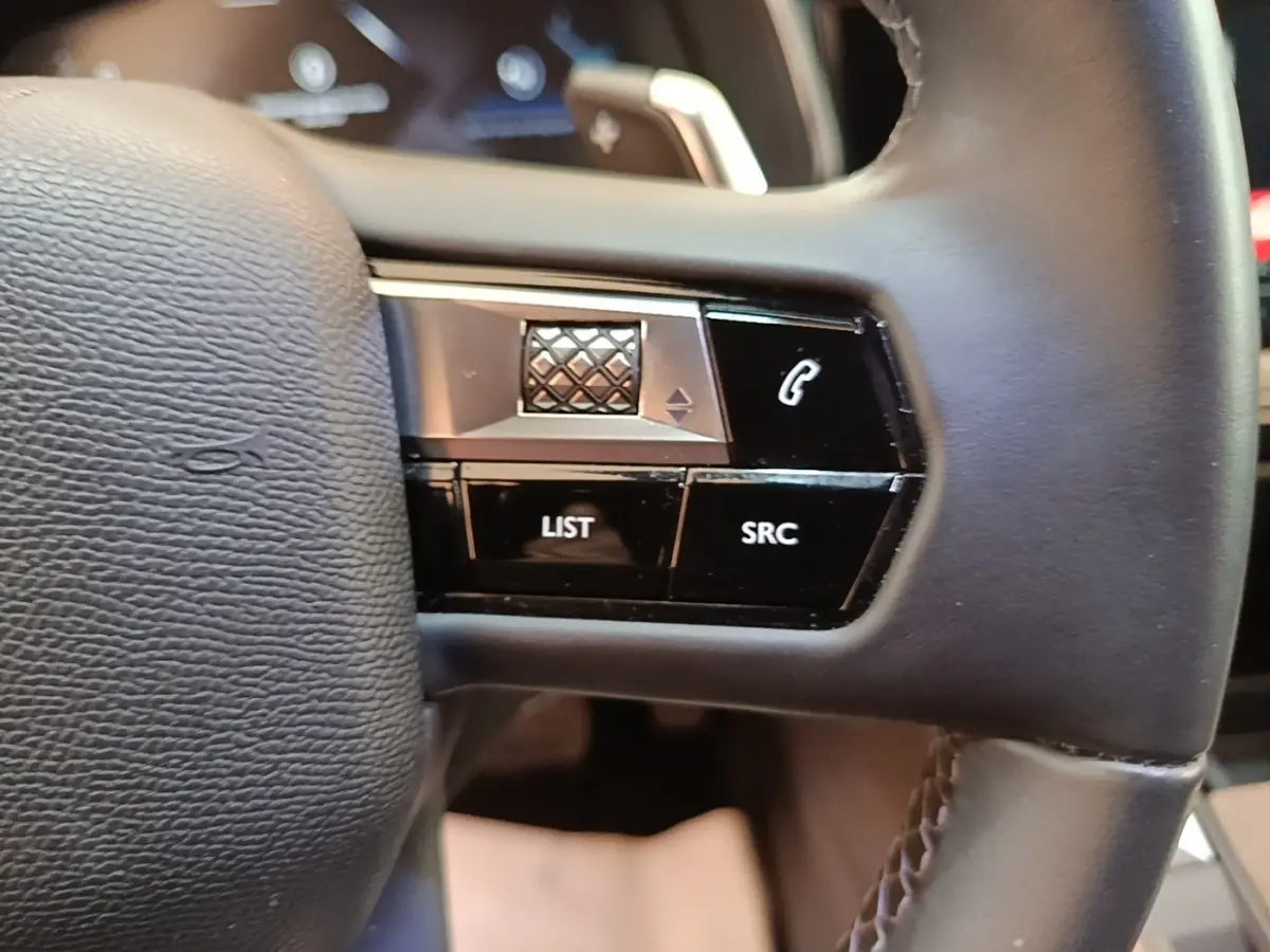 Gros plan sur le volant cuir multifonctions du DS7 Crossback E-TENSE 225 BUSINESS, boutons de commande visibles.