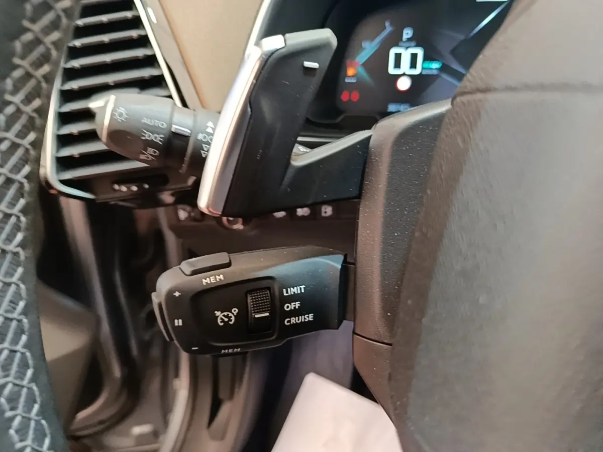 Gros plan sur le volant cuir noir de la DS7 Crossback E-TENSE 225, avec commandes de régulateur de vitesse visibles.